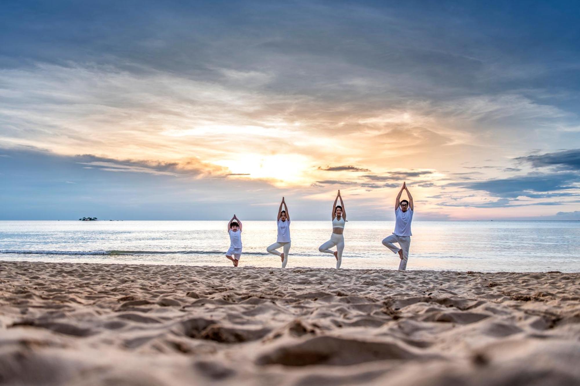 Hotel Vinpearl Wonderworld Phú Quý Zewnętrze zdjęcie Family practicing yoga on the beach
